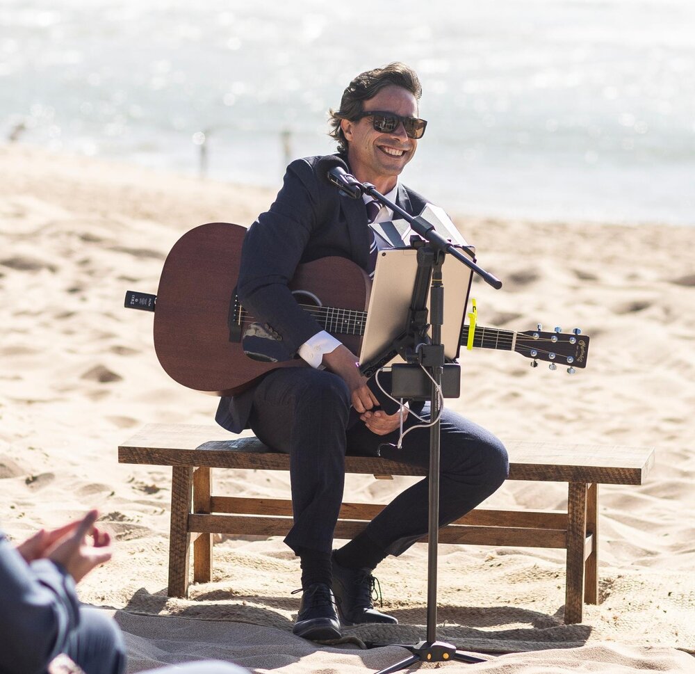 Samuel da Rosa com guitarra na praia